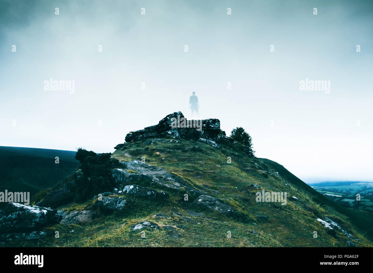 A spooky figure of a man walking along a country track, with a desaturated look. Stock Photo