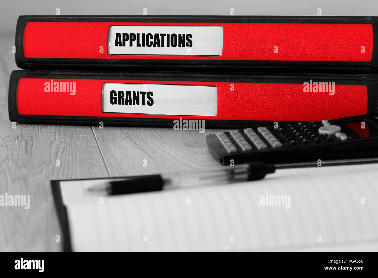 Red folders with applications and grants written on the label on a desk with selective colour Stock Photo