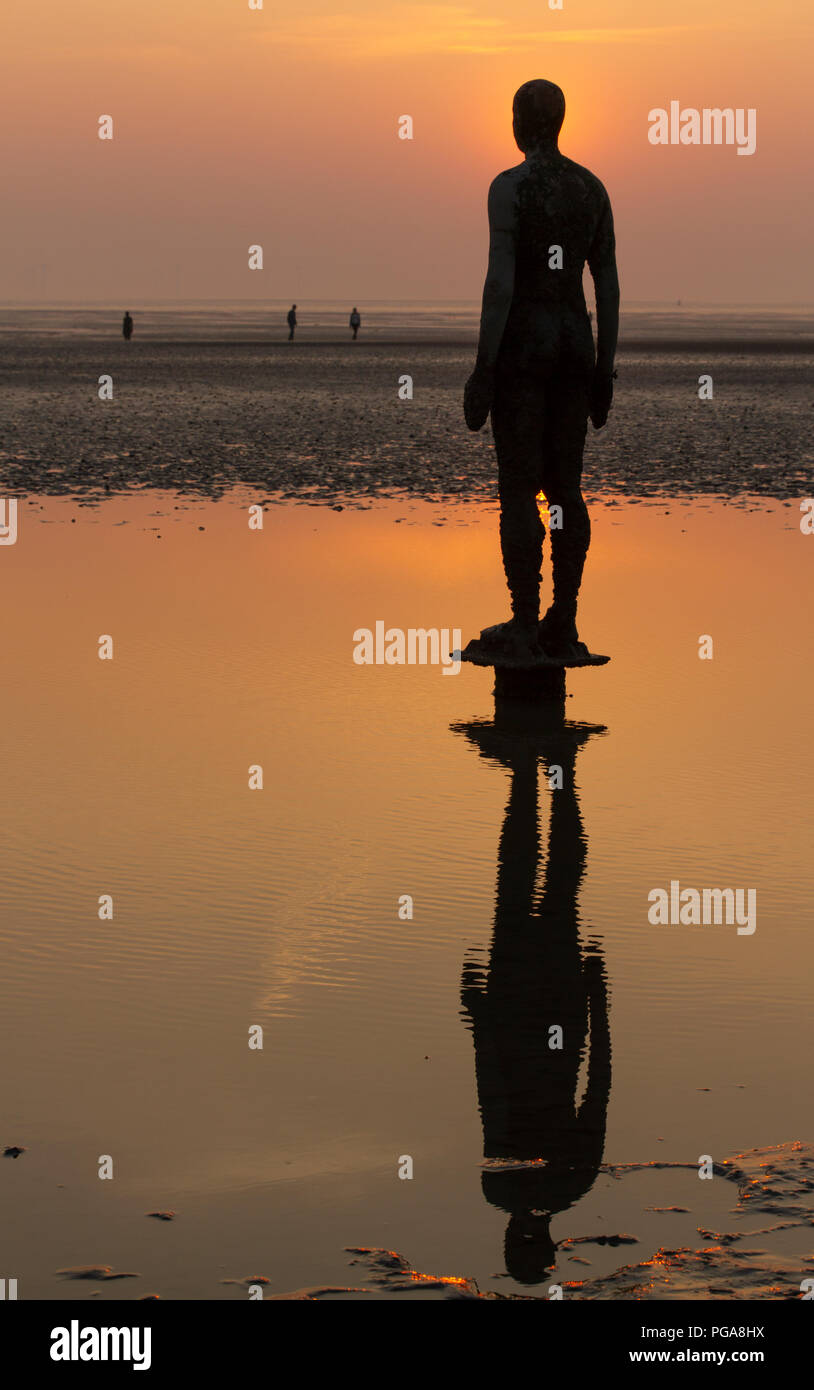 Antony Gormley Statues stand waiting on Crosby Beach for the tide to