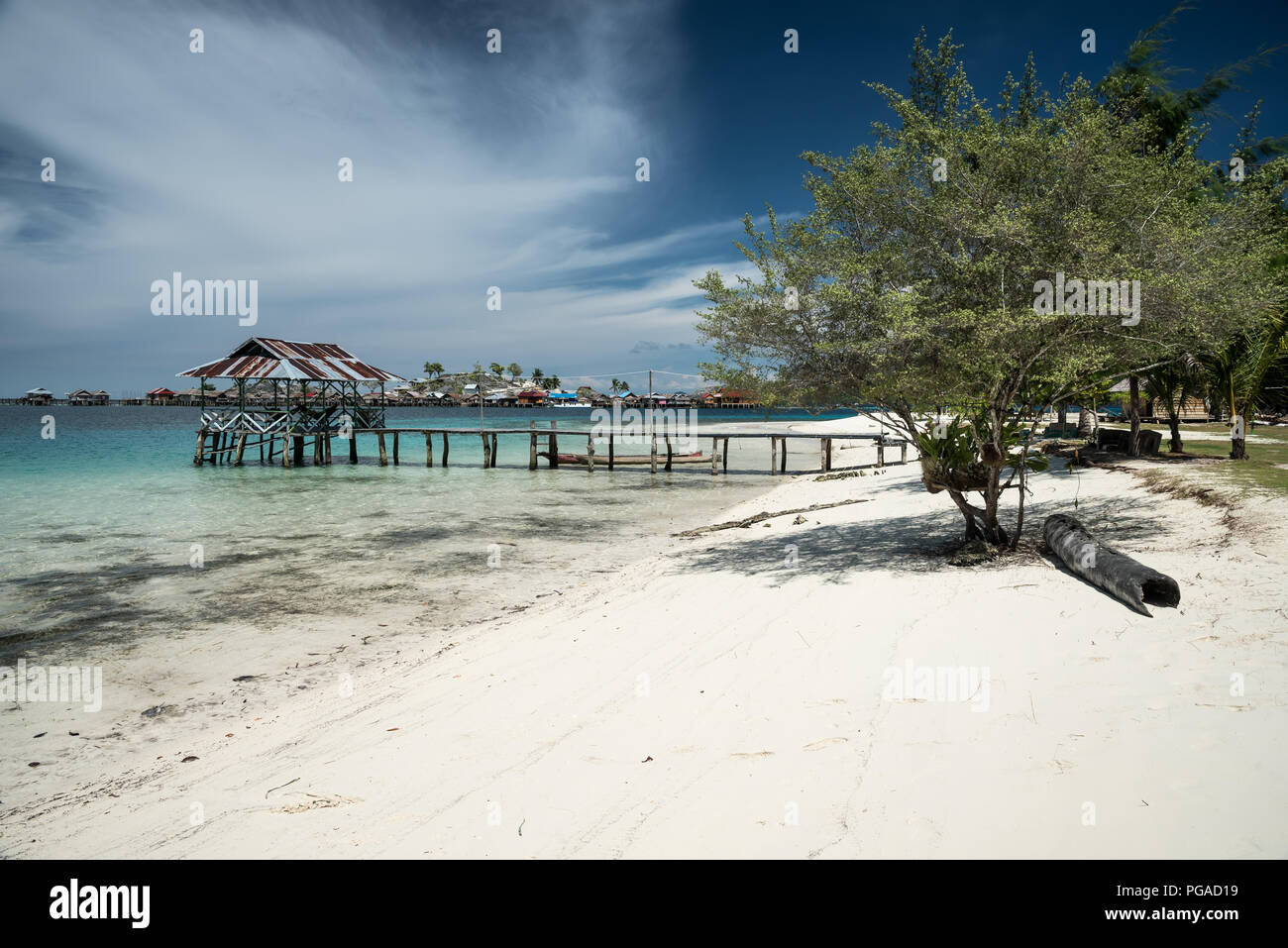 Tropical sand beach resort on remote Malenge island, part of Togean archipelago with traditional boats, Lestari, Indonesia Stock Photo