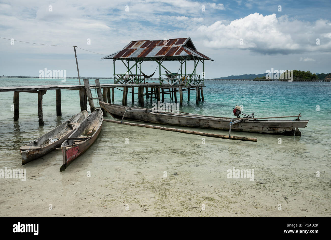 Tropical sand beach resort on remote Malenge island, part of Togean archipelago with traditional boats, Indonesia Stock Photo