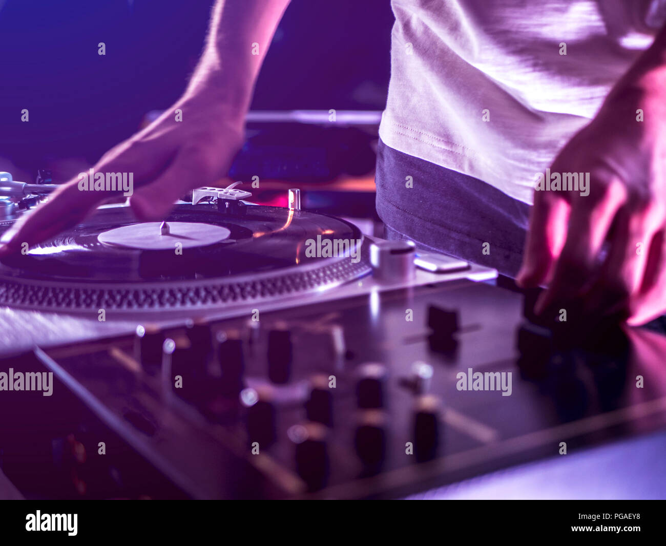 close up dj hand play music on turntable record setup at home party tomed vintage look Stock Photo