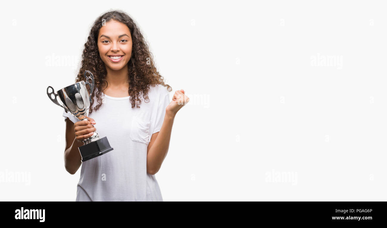 Young hispanic woman holding trophy screaming proud and celebrating victory  and success very excited, cheering emotion Stock Photo - Alamy