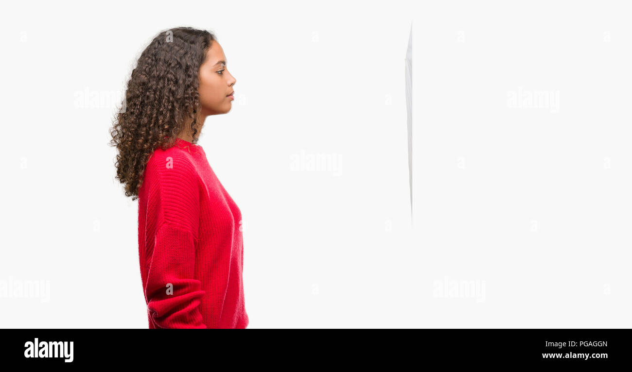 Young hispanic woman wearing red sweater looking to side, relax profile  pose with natural face with confident smile Stock Photo - Alamy