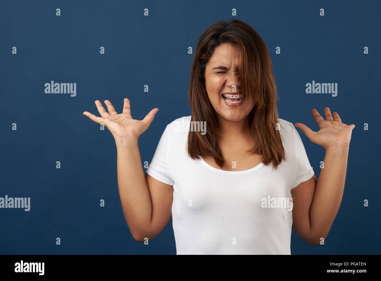 Screaming young woman isolated on blue studio background Stock Photo
