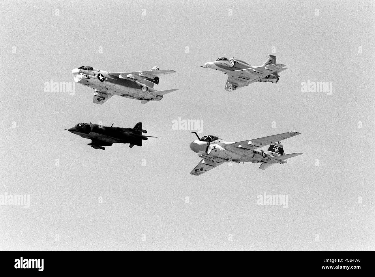 Ground-to-air view of four aircraft flying in formation during Test and Evaluation Squadron Five (VX-5) airshow.  The aircraft over Armitage Field, are (from left to right, clockwise) an A-7E Corsair II, an A-4M Skyhawk, and A-6E Intruder and an AV-8C Harrier. Stock Photo