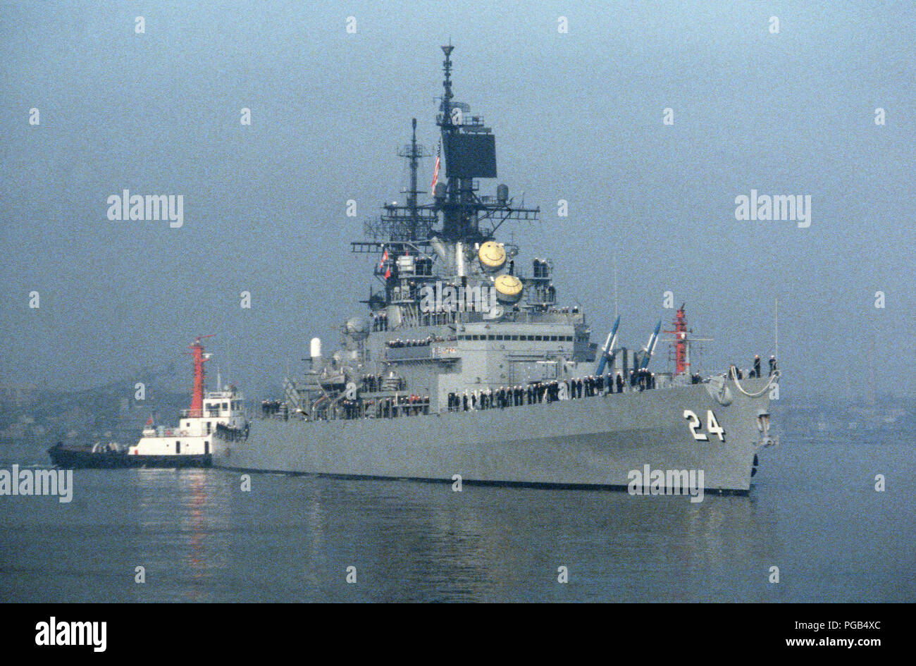 A tug assists the guided missile cruiser USS REEVES (CG 24) into port ...