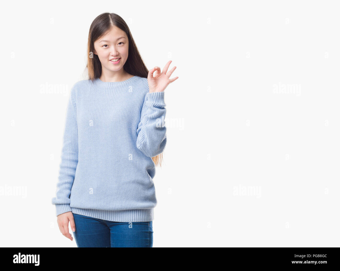 Young Chinese woman over isolated background smiling positive doing ok sign with hand and fingers. Successful expression. Stock Photo