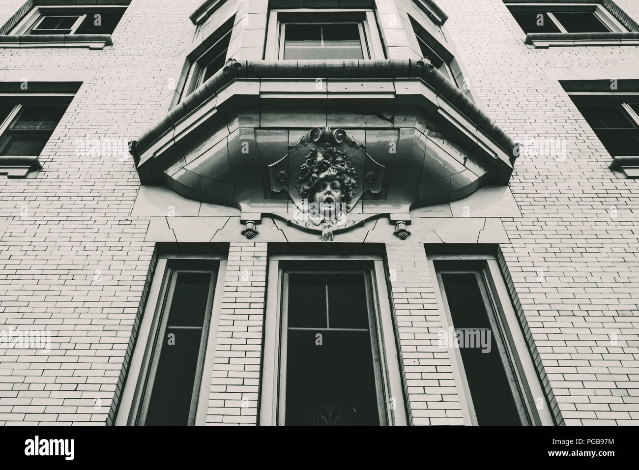 Monochrome perspective view of the windows of an old downtown building. Stock Photo