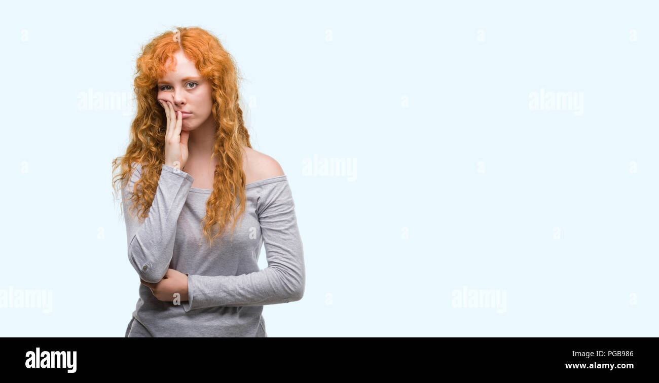 Annoyed and upset tired redhead curly woman in yellow sweater