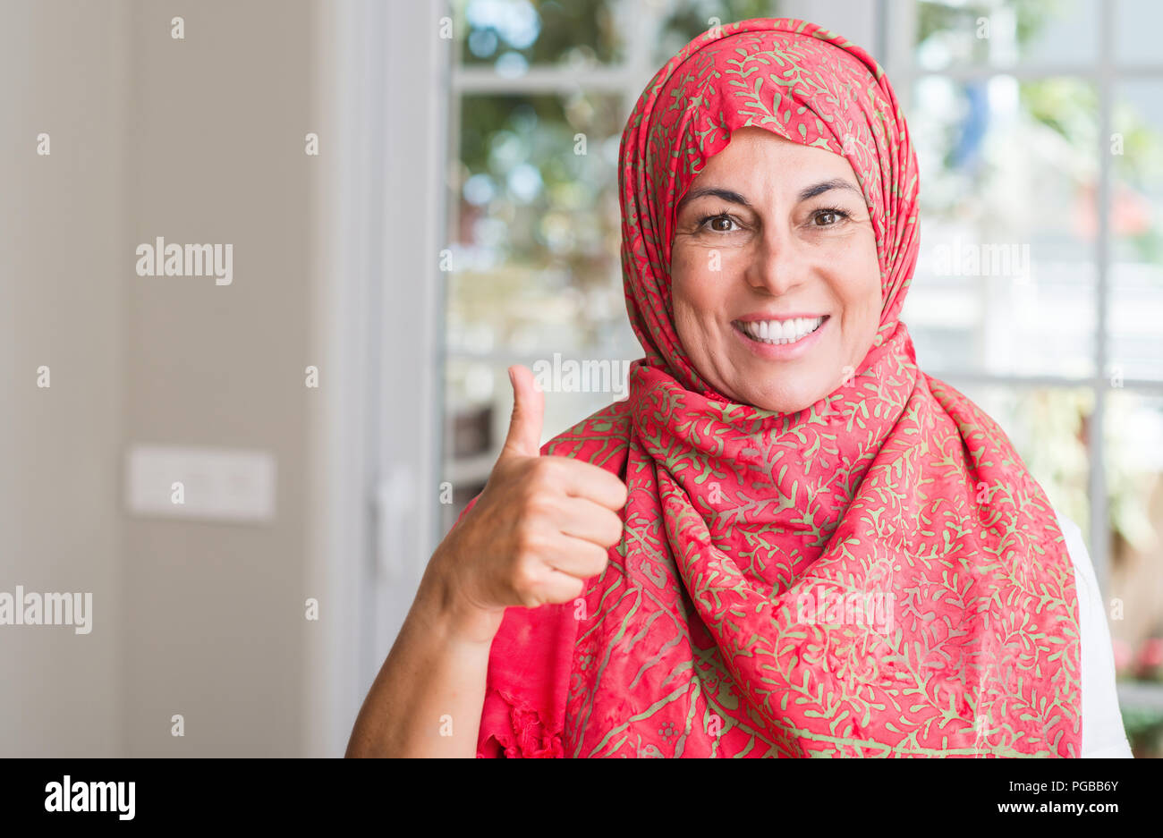 Middle aged muslim woman wearing hijab happy with big smile doing ok ...