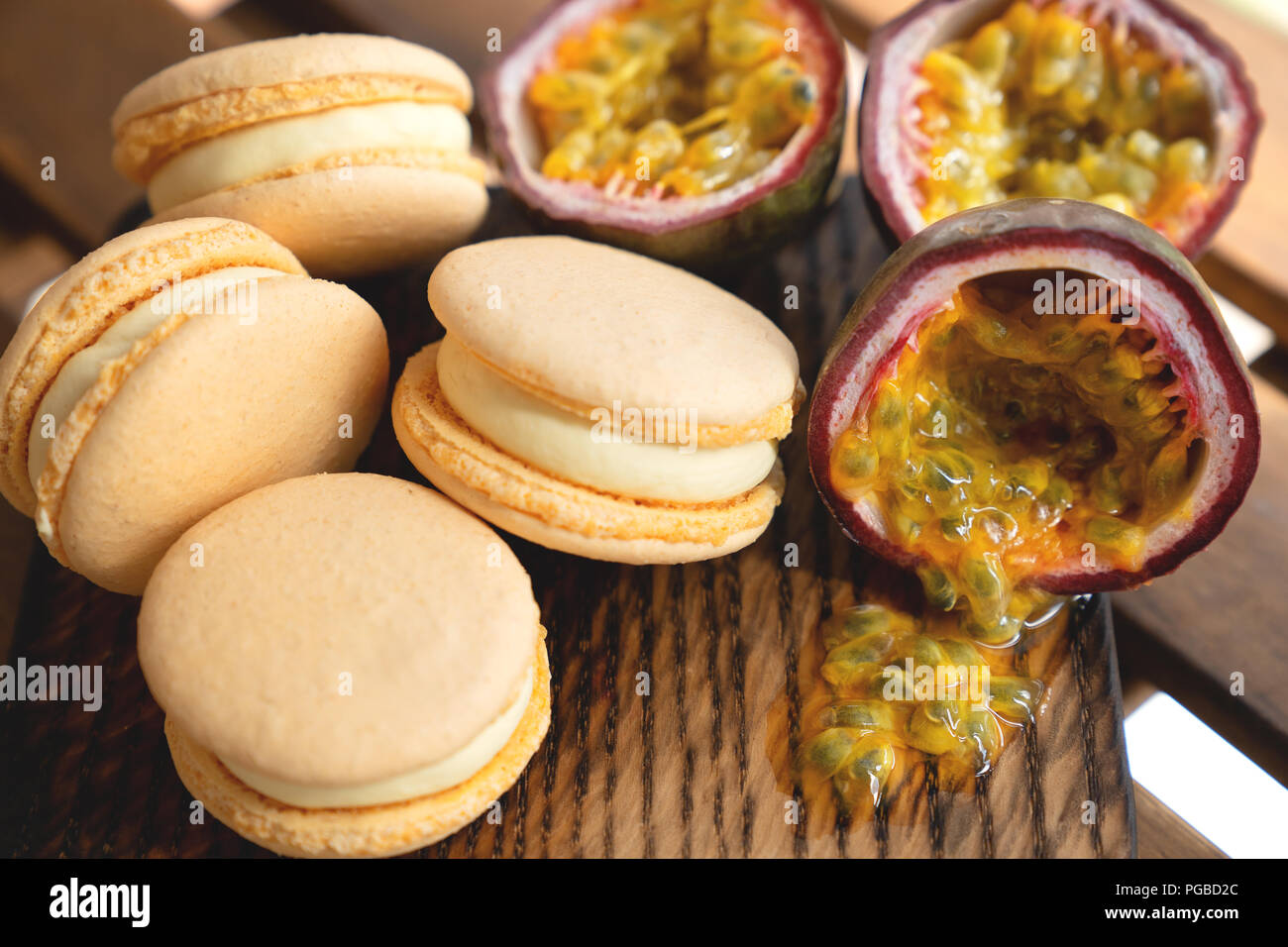 Passion fruit with macarons on wooden background Stock Photo