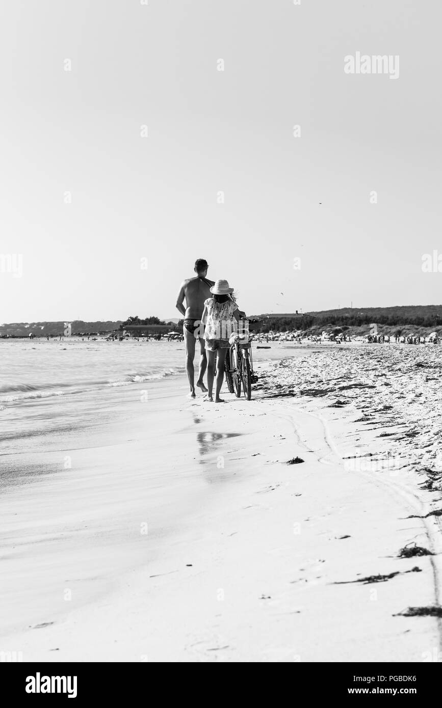 A couple walks along the white beach of Rosignano Solvay Stock Photo