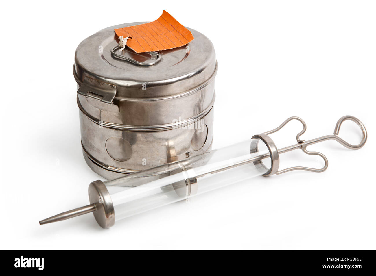 Steam sterilizer and large syringe with thick needle isolated on white