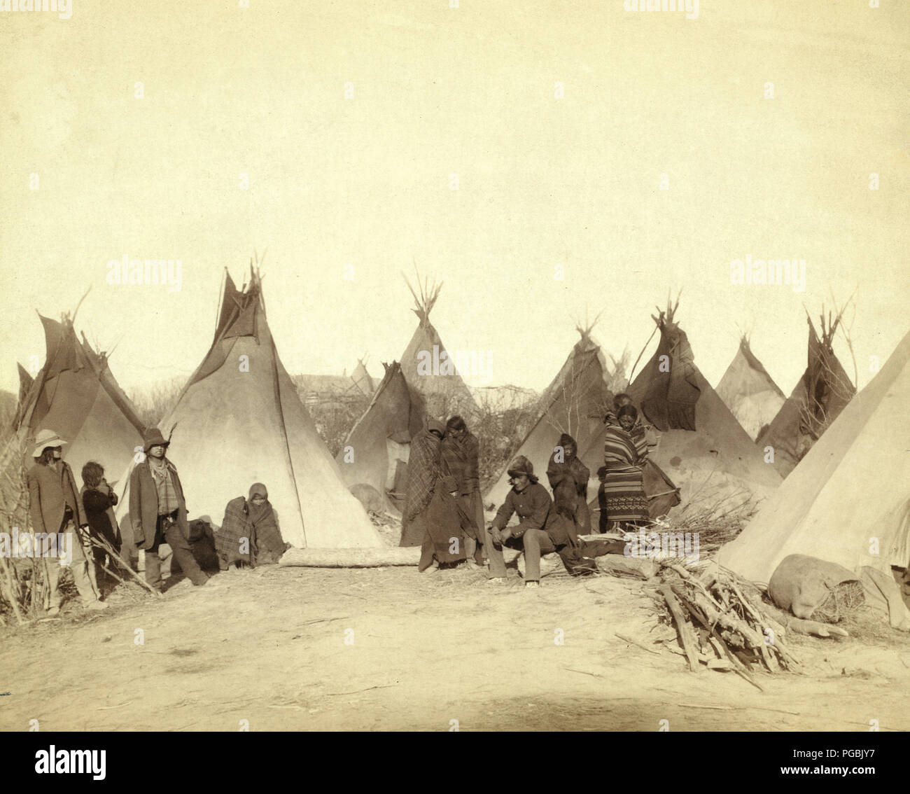 Group of twelve Miniconjou (children and adults)--many are looking away from camera--in a tepee camp, probably on or near Pine Ridge Reservation. 1891 Stock Photo