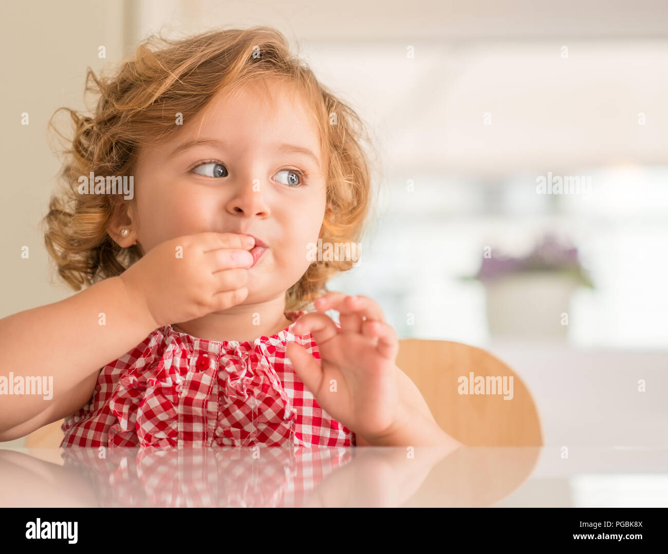 Beautiful Blonde Child With Blue Eyes Eating Candy And Looking