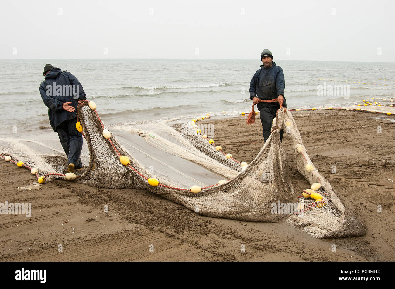 Fishermen pull the fishing net out of the sea in caspian sea Stock