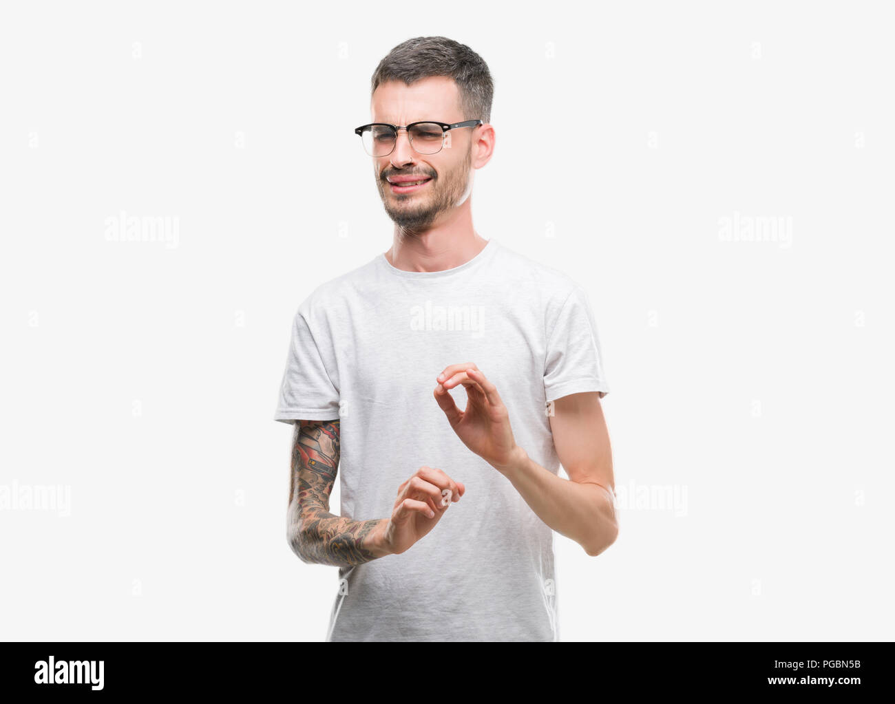 Young tattooed adult man disgusted expression, displeased and fearful doing disgust face because aversion reaction. With hands raised. Annoying concep Stock Photo