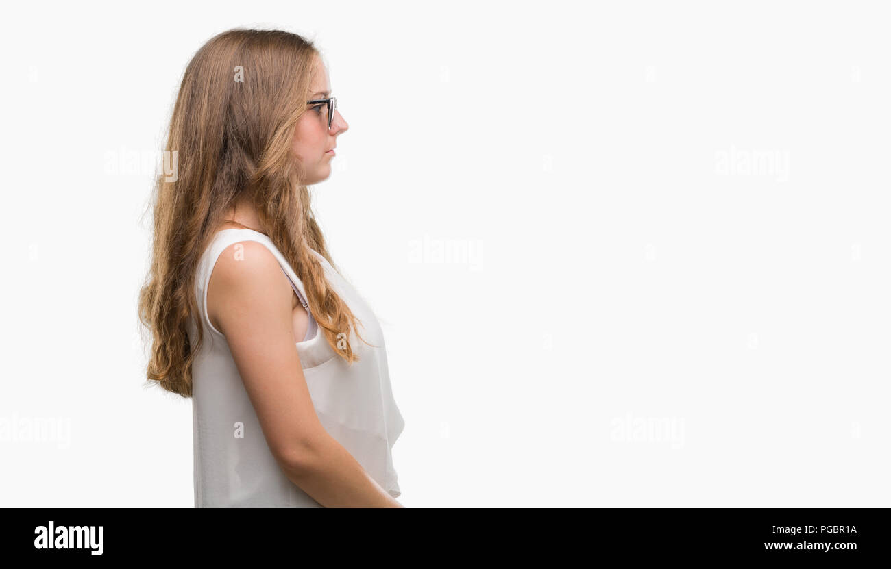 Young blonde woman wearing sunglasses looking to side, relax profile pose with natural face with confident smile. Stock Photo