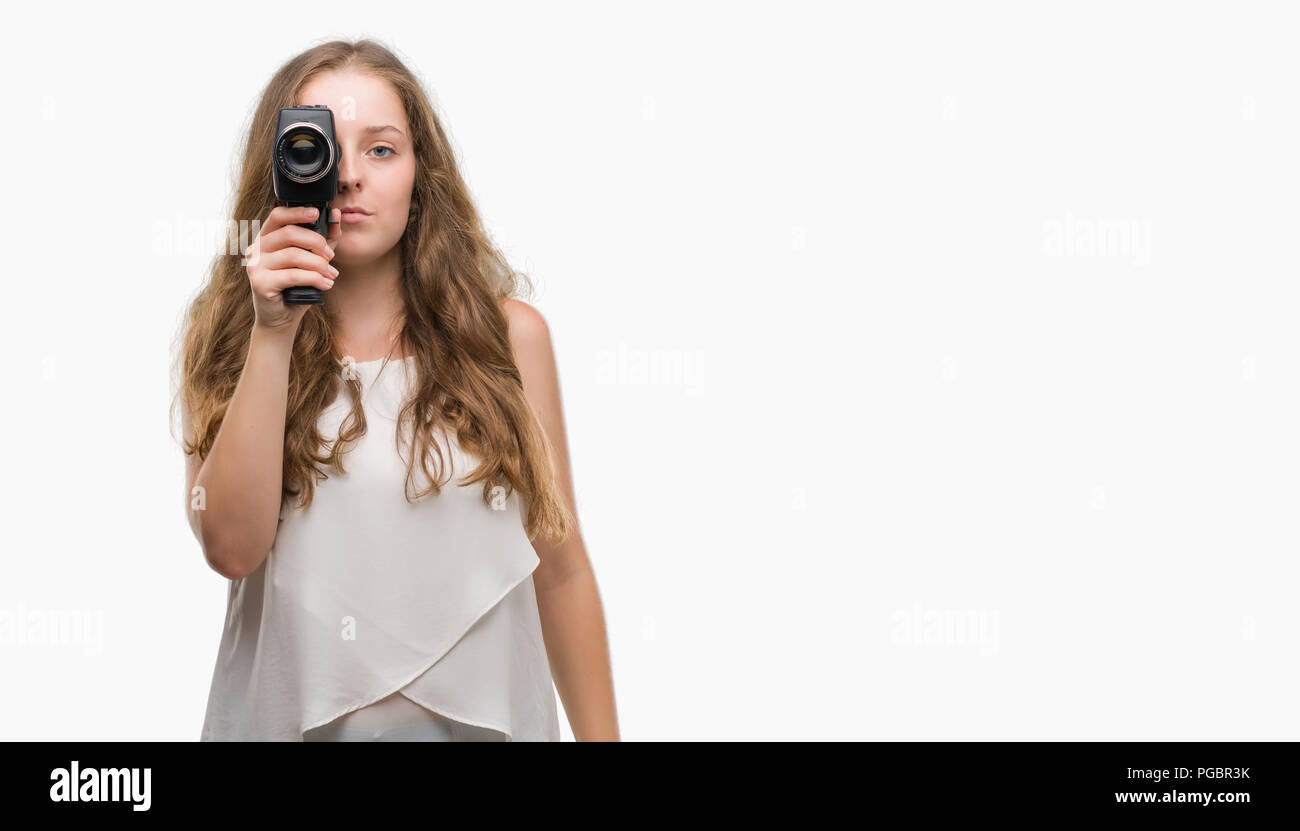 Young blonde woman holding super 8 video camera with a confident expression on smart face thinking serious Stock Photo