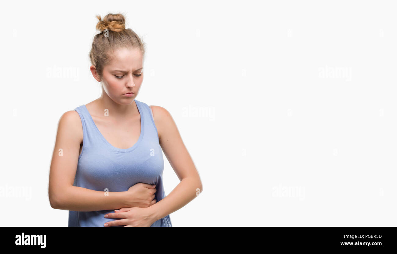 Young blonde woman with hand on stomach because nausea, painful disease feeling unwell. Ache concept. Stock Photo