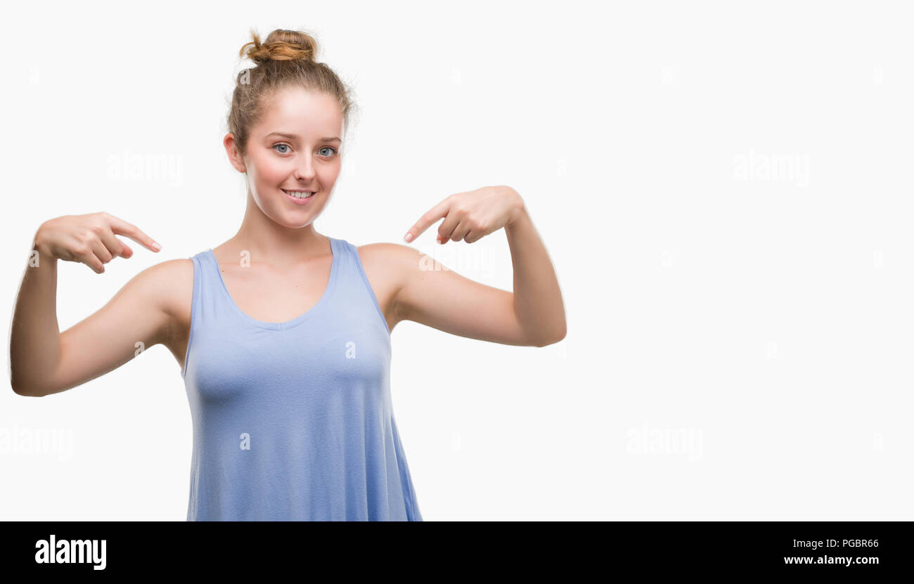 Young blonde woman looking confident with smile on face, pointing oneself with fingers proud and happy. Stock Photo
