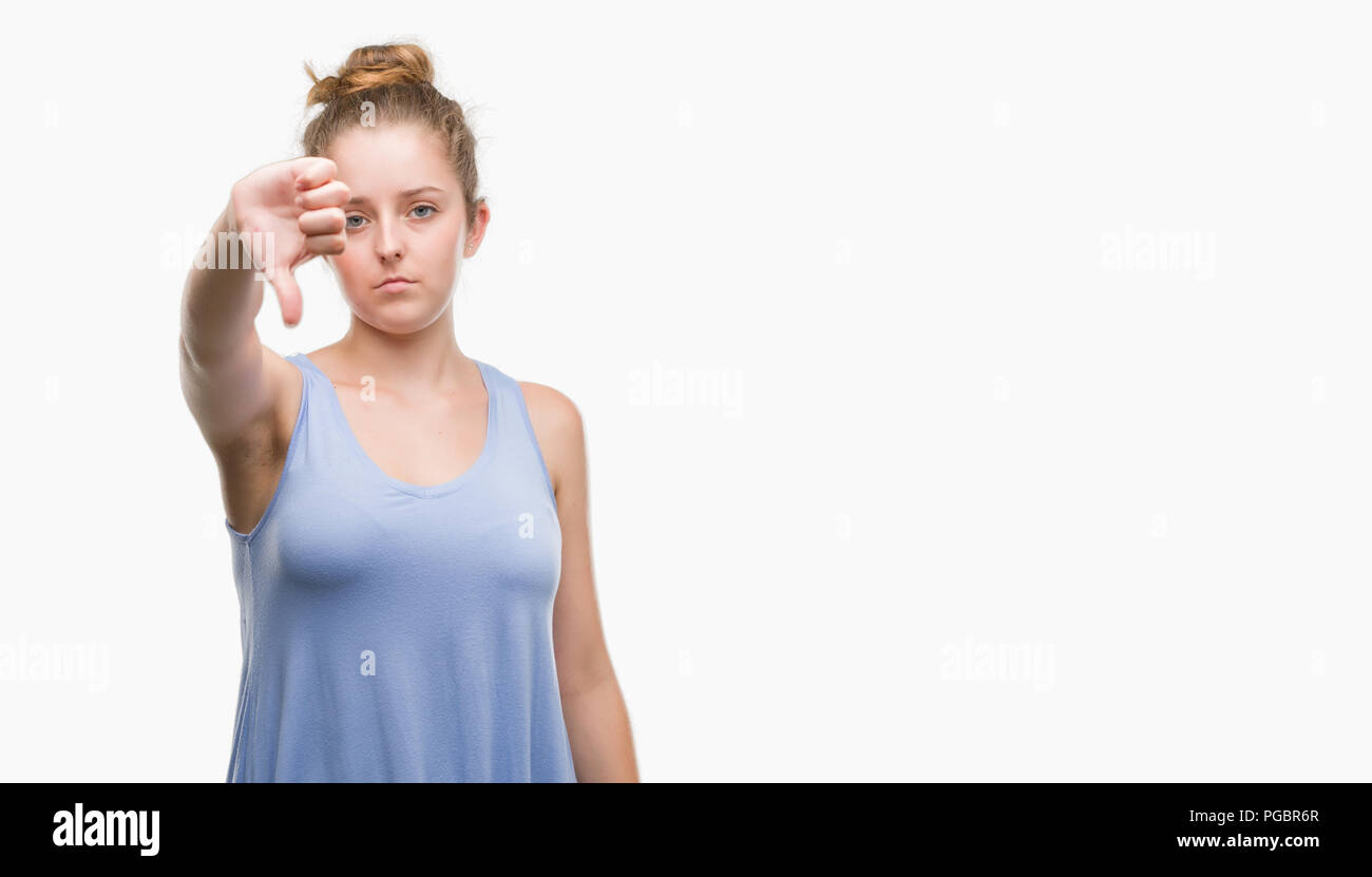 Young blonde woman looking unhappy and angry showing rejection and negative with thumbs down gesture. Bad expression. Stock Photo