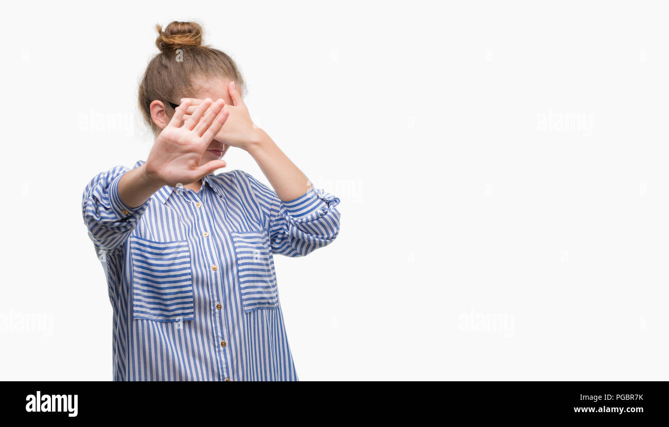 Young blonde business woman covering eyes with hands and doing stop gesture with sad and fear expression. Embarrassed and negative concept. Stock Photo