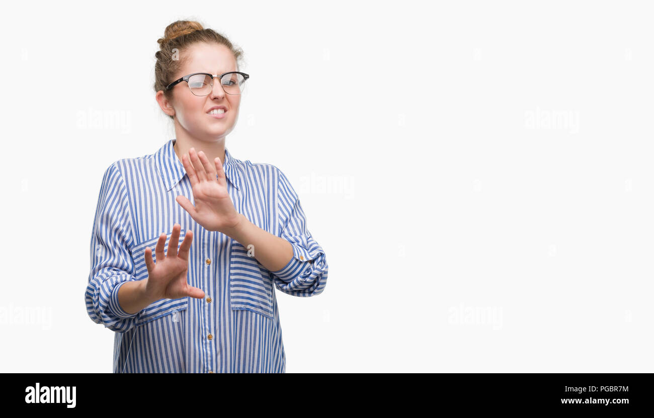 Young blonde business woman disgusted expression, displeased and fearful doing disgust face because aversion reaction. With hands raised. Annoying con Stock Photo