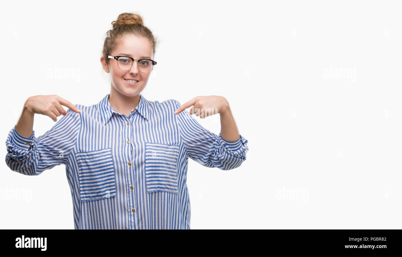 Young blonde business woman looking confident with smile on face, pointing oneself with fingers proud and happy. Stock Photo