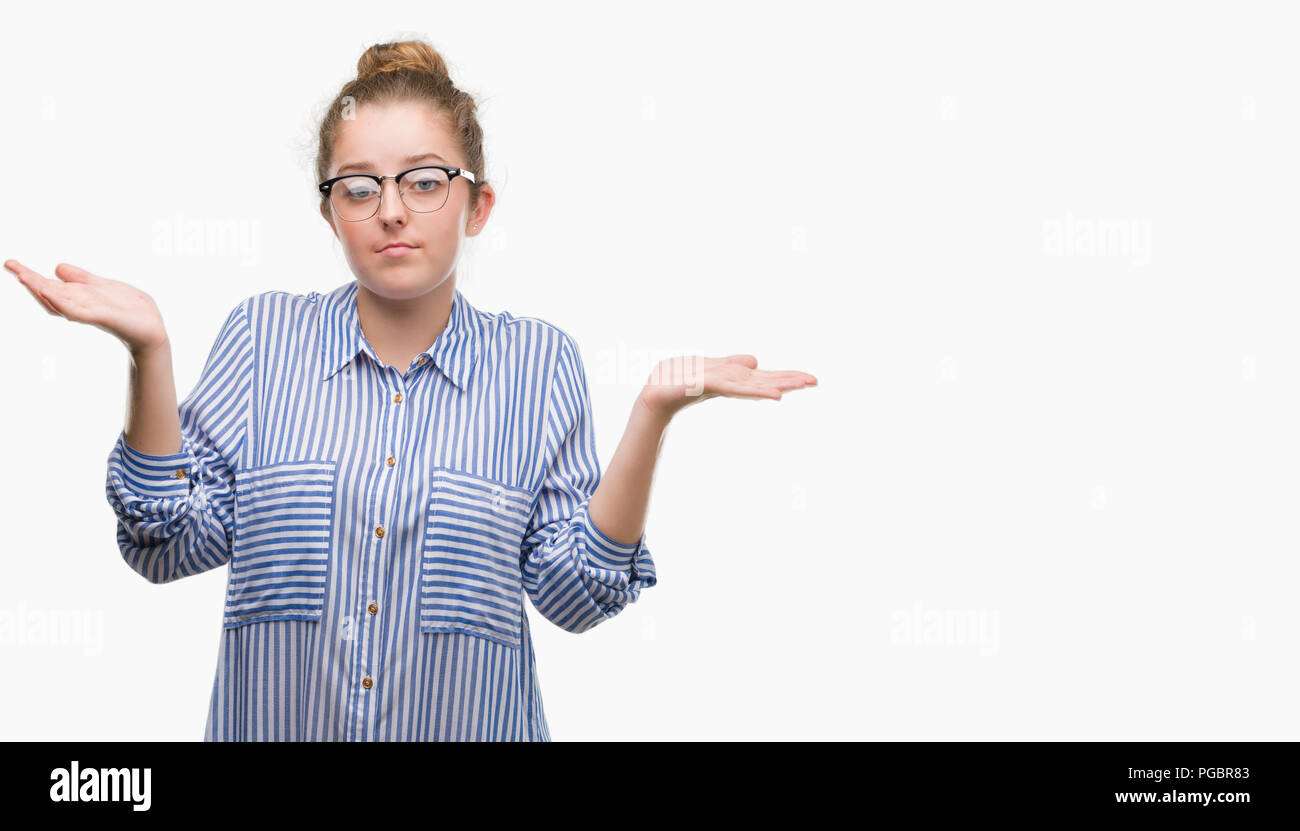 Young blonde business woman clueless and confused expression with arms and hands raised. Doubt concept. Stock Photo