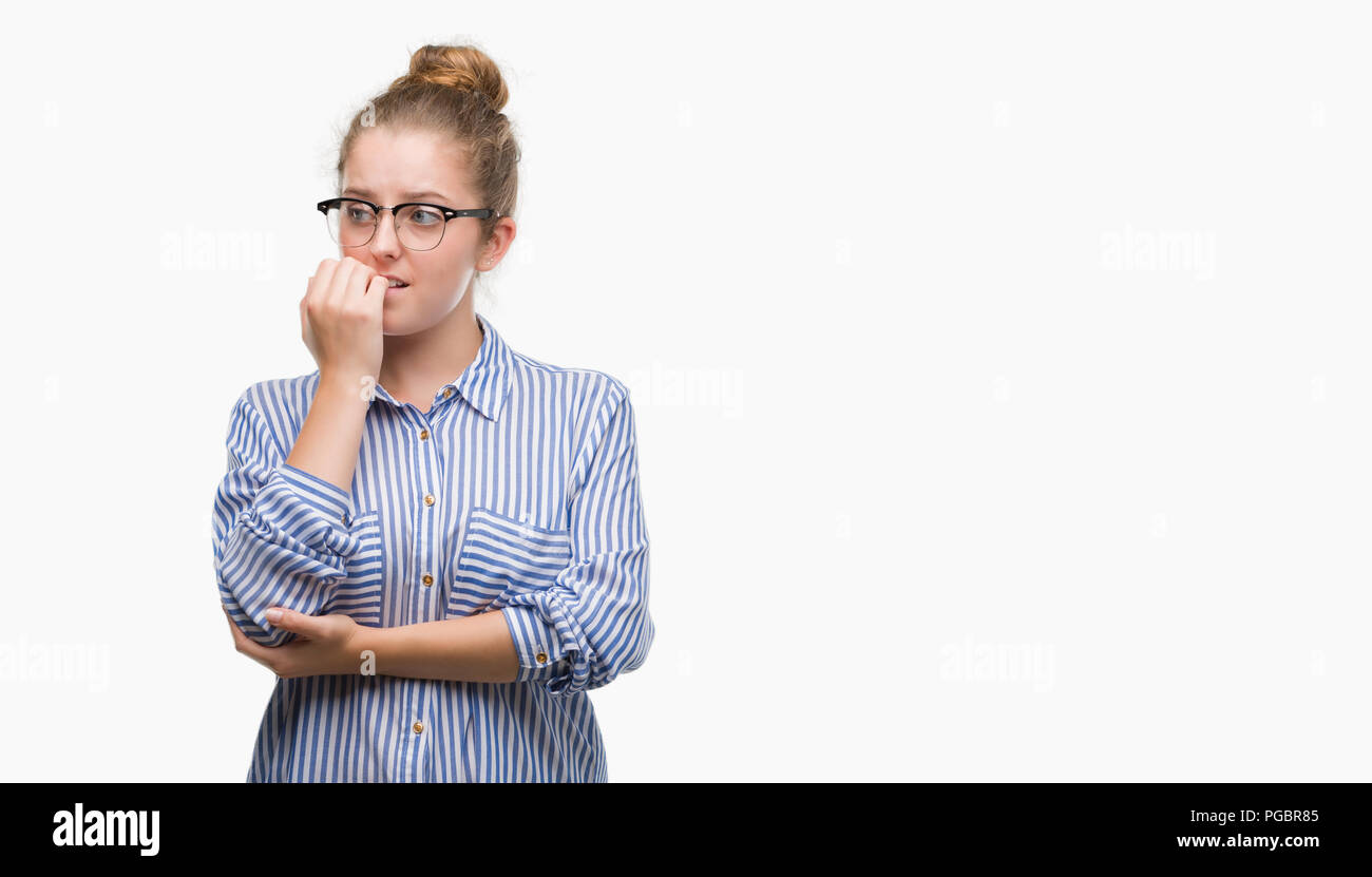 Young blonde business woman looking stressed and nervous with hands on mouth biting nails. Anxiety problem. Stock Photo