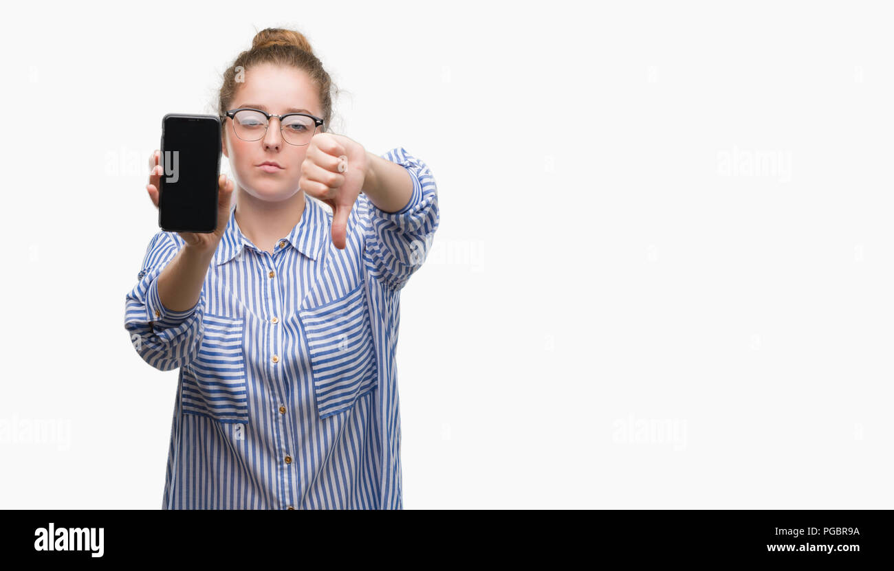 Young blonde woman using smartphone with angry face, negative sign showing dislike with thumbs down, rejection concept Stock Photo