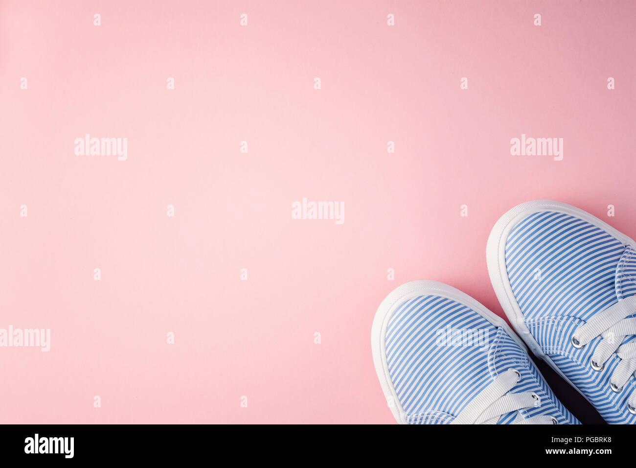 blue female sneakers with laces on pink background with copy space ...
