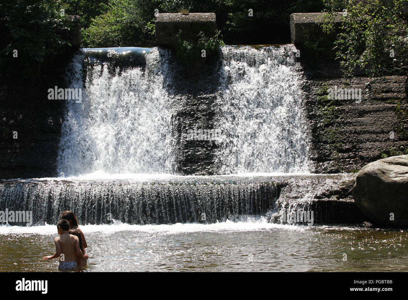 Children play in an unguarded pool on a hot sunny day in the nature