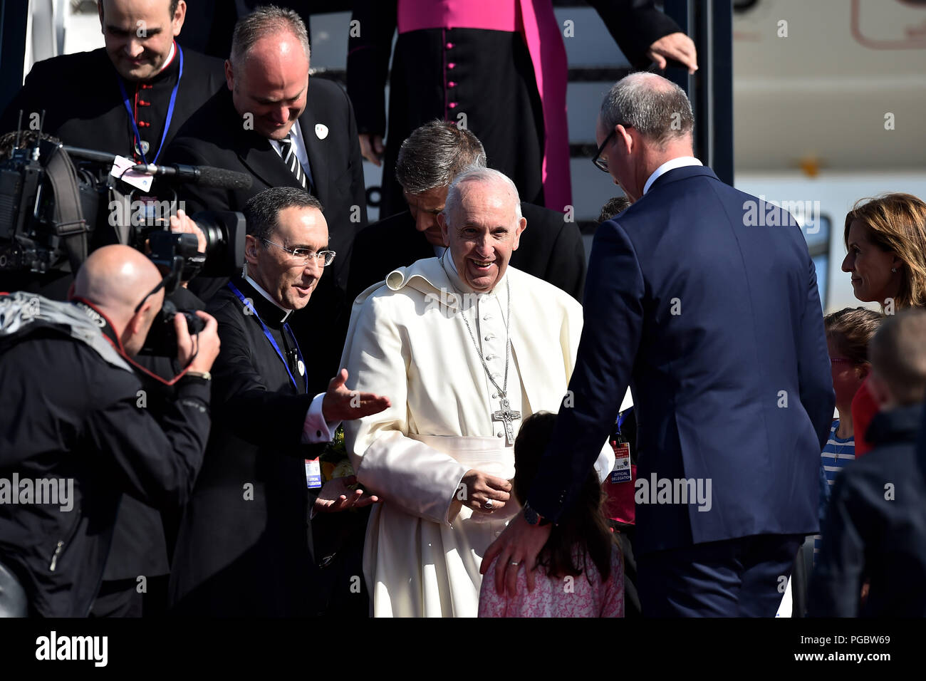 Pope Francis is greeted by Simon Coveney, Irish Minister for Foreign Affairs and his daughters as he arrives at Dublin Airport as he arrives at Dublin Airport as he arrives at Dublin International Airport, at the start of his visit to Ireland. Stock Photo