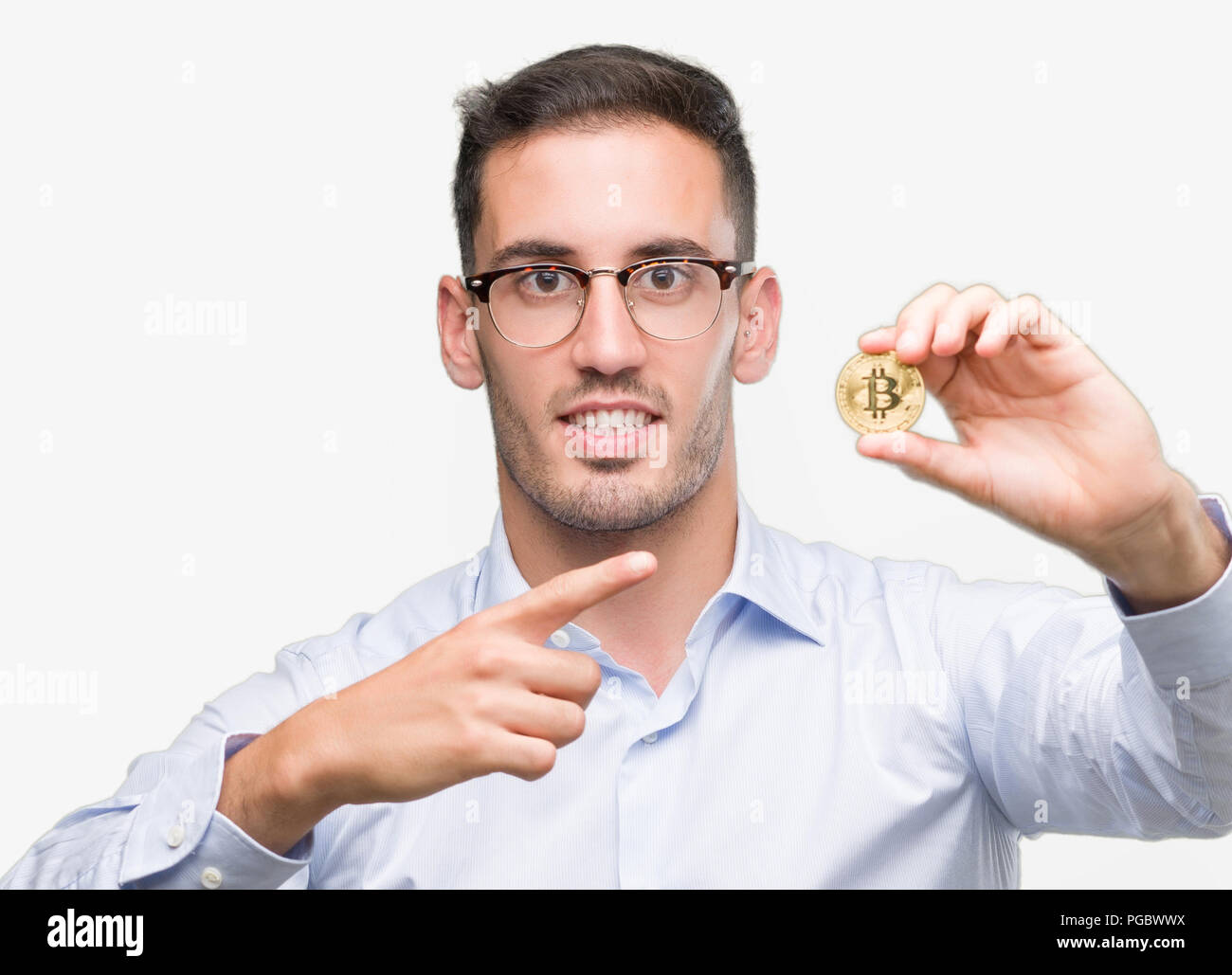 Handsome young man holding bitcoin very happy pointing with hand and finger  Stock Photo - Alamy