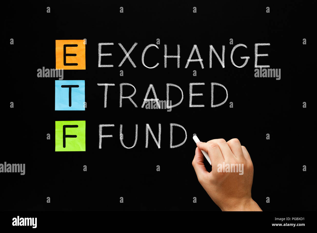 Hand writing ETF - Exchange Traded Fund with white chalk on blackboard. Stock Photo