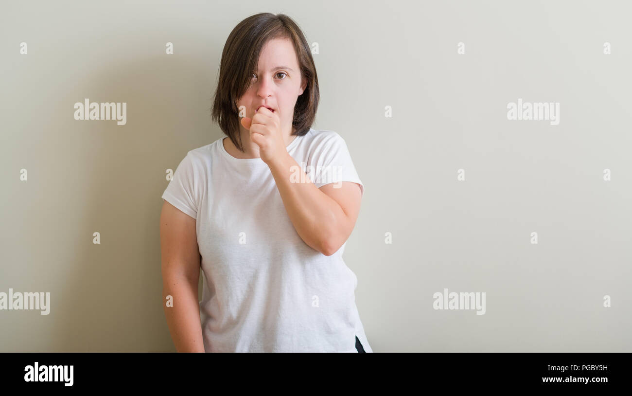 Down syndrome woman standing over wall feeling unwell and coughing as ...