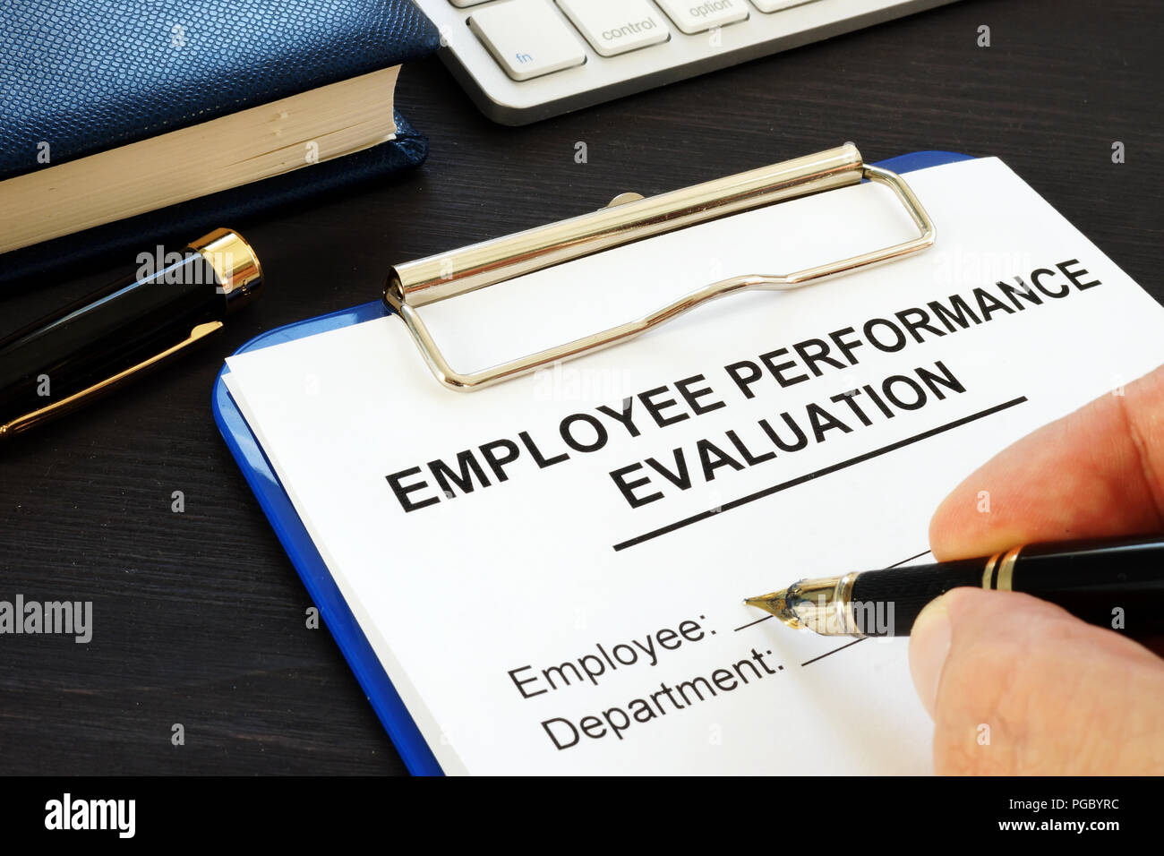 Clipboard with employee performance evaluation and pen. Stock Photo
