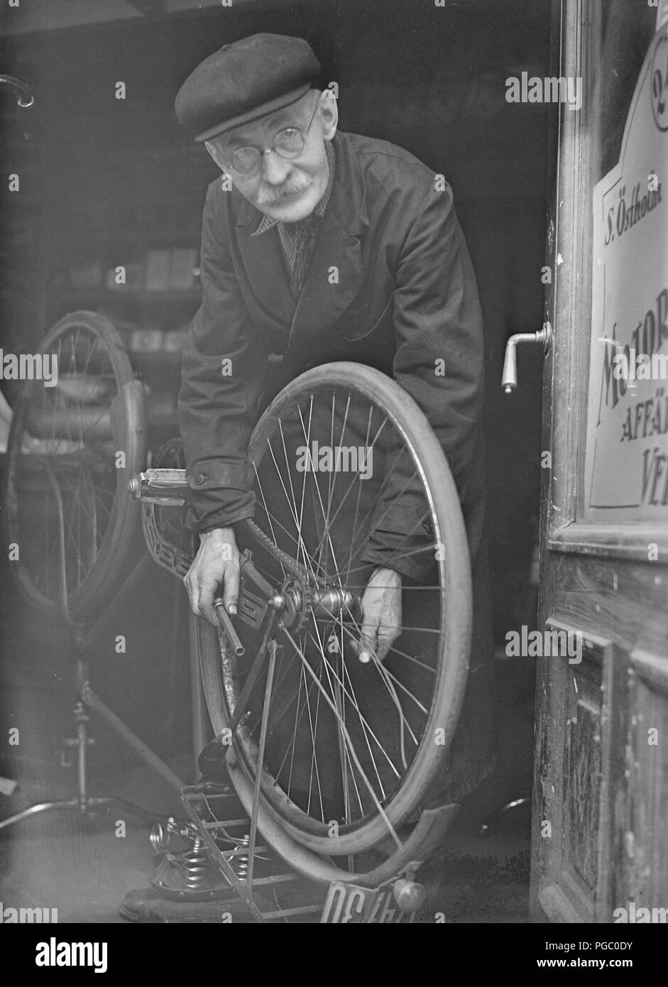 1940s Bicycle Repair Man An Elderly Man In The Doorway Of His Bicycle Repair Shop He Has Bicycle Upside Down And Is Working On Removing The Back Wheel Sweden May 1940 Photo