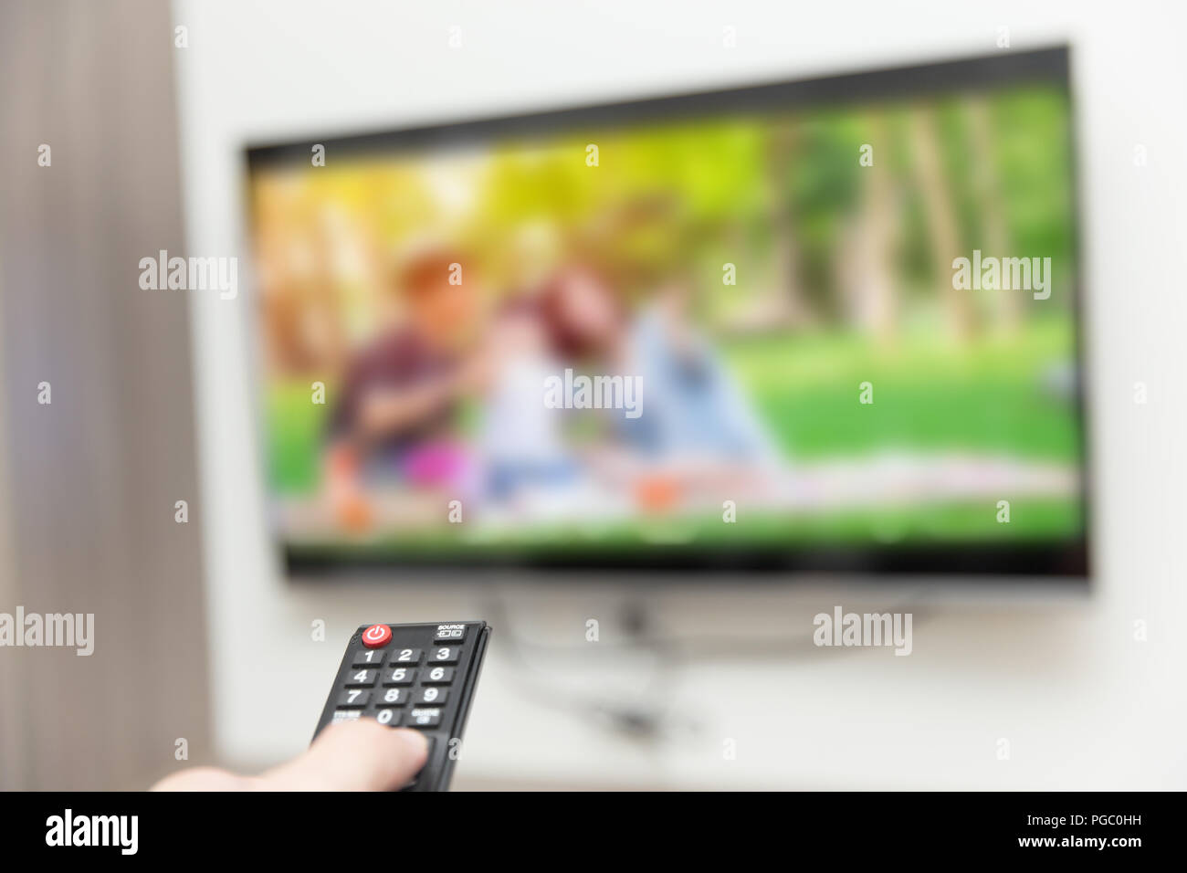 people watching tv hand with remote control smart television Stock Photo