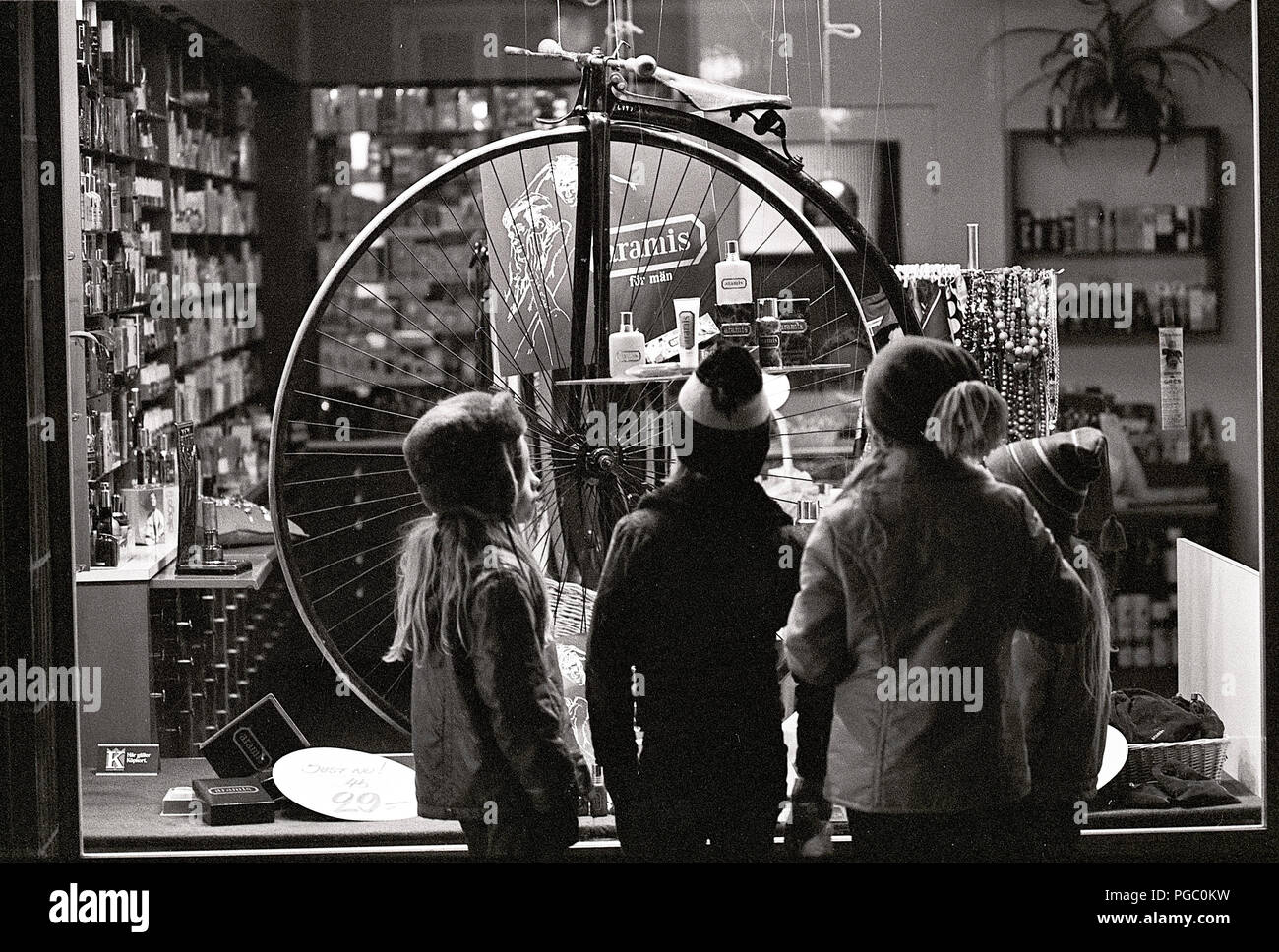 1970s store. A group of children is standing in front of a store and looking at a Penny-farthing bicycle. Sweden 1970s Stock Photo