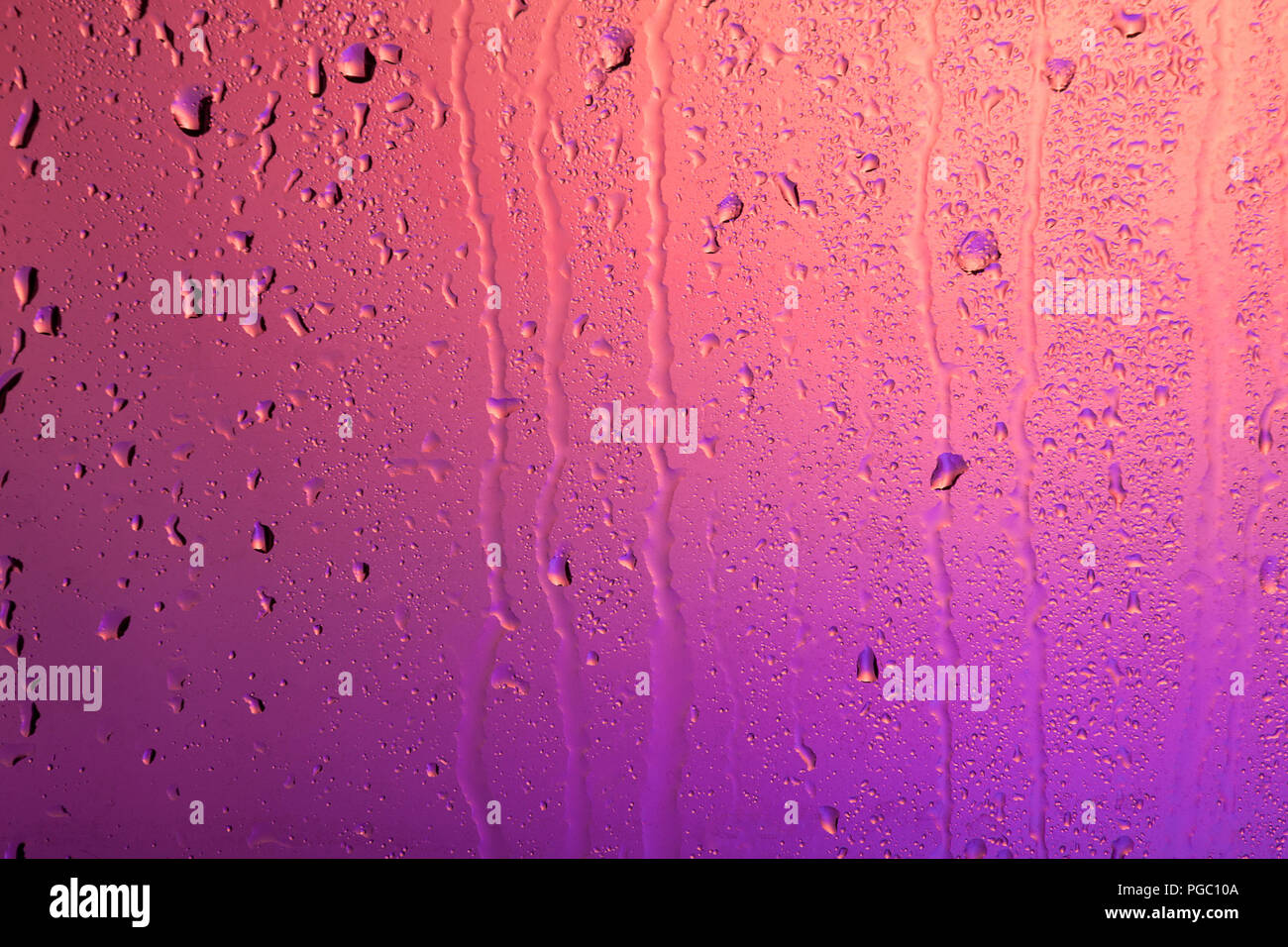 Rainy window. Drops on the glass in purple back light Stock Photo - Alamy