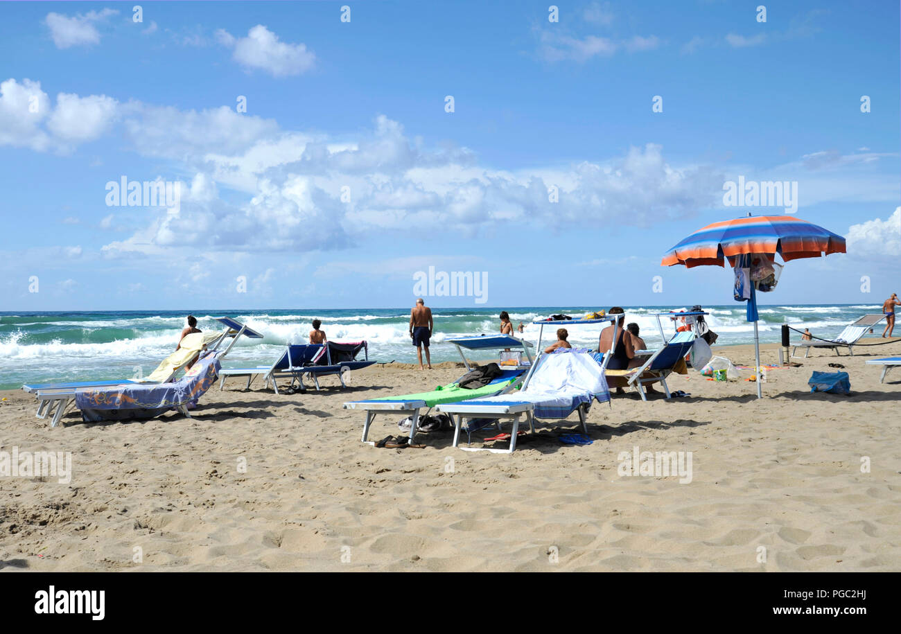 Relaxed people on the Sabaudia beach for the summer holidays. The sea on the background. Sabaudia, Lazio, Italy. Stock Photo