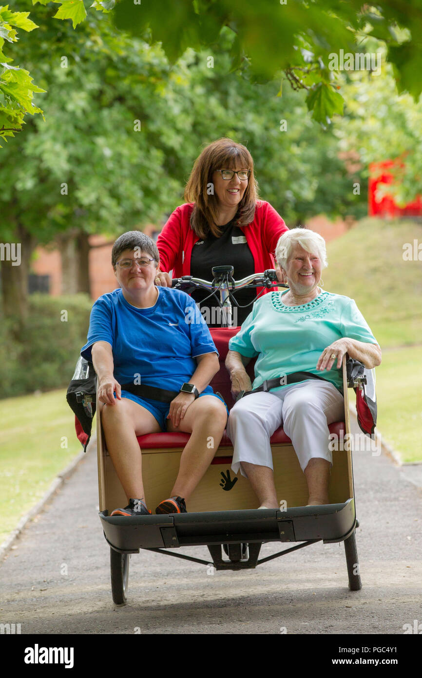 Elderly women getting a ride on a bike Stock Photo