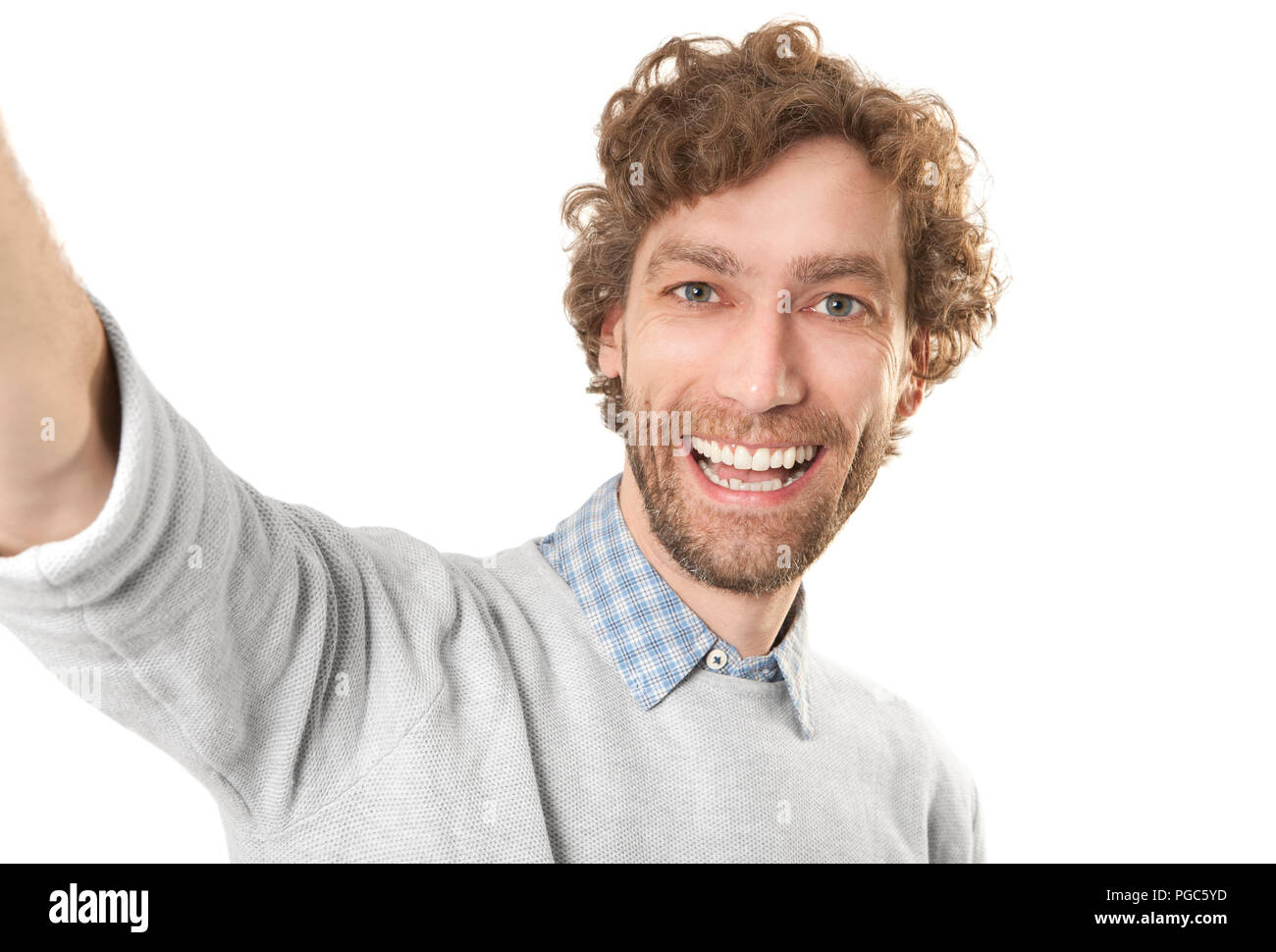 a young laughing man makes a selfi against a white background Stock Photo