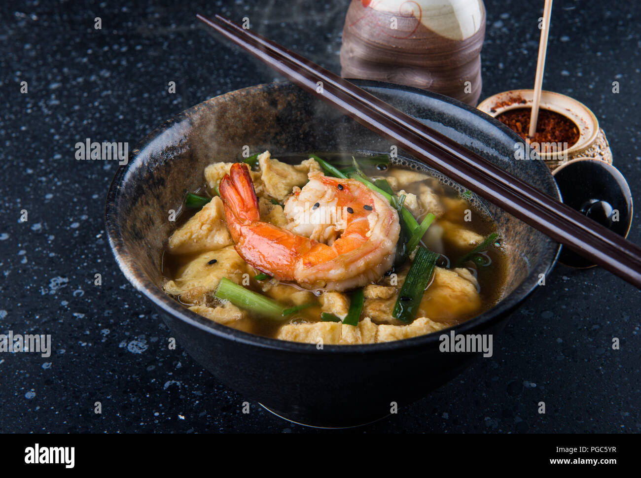 Asian egg soup style with soy sauce and big prawn serve in Japanese restaurant. Stock Photo