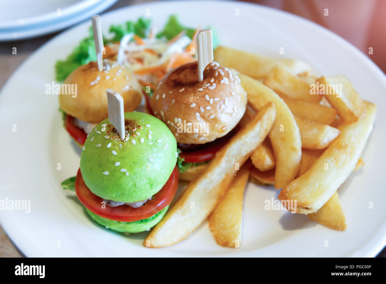 burger set in white plate with indoor lighting Stock - Alamy