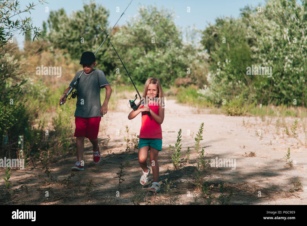 Young siblings walking on a path with your fishing rod Stock Photo - Alamy